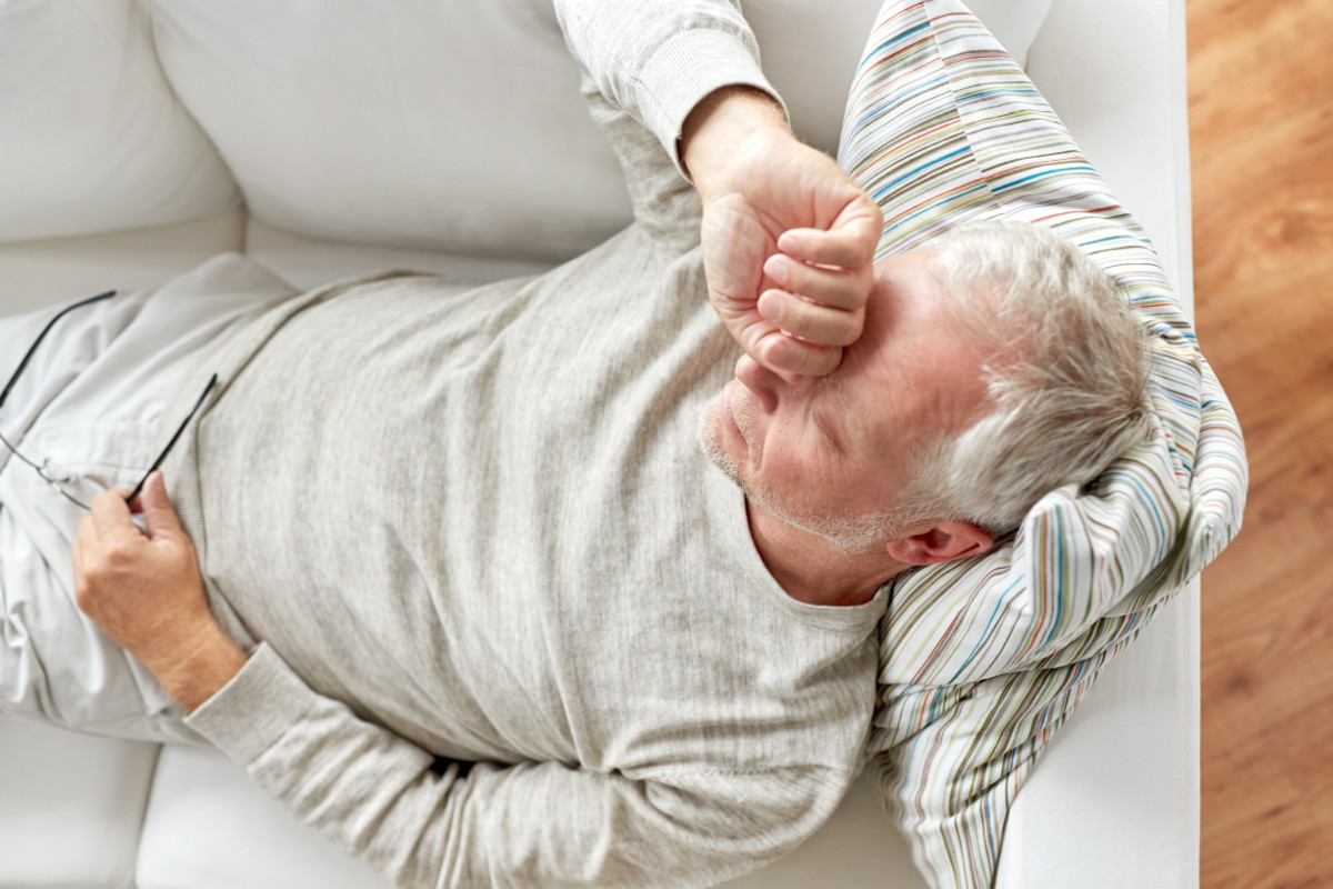 old age, problem and people concept - close up of tired senior man lying on sofa at home